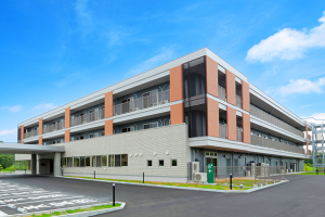 赤褐色とグレーの外壁が特徴的な3階建ての介護施設の建物外観